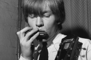 Brian Jones (1942 - 1969) of the group The Rolling Stones playing a harmonica with one hand and clutching a guitar in his other. (Photo by Chris Ware/Getty Images)